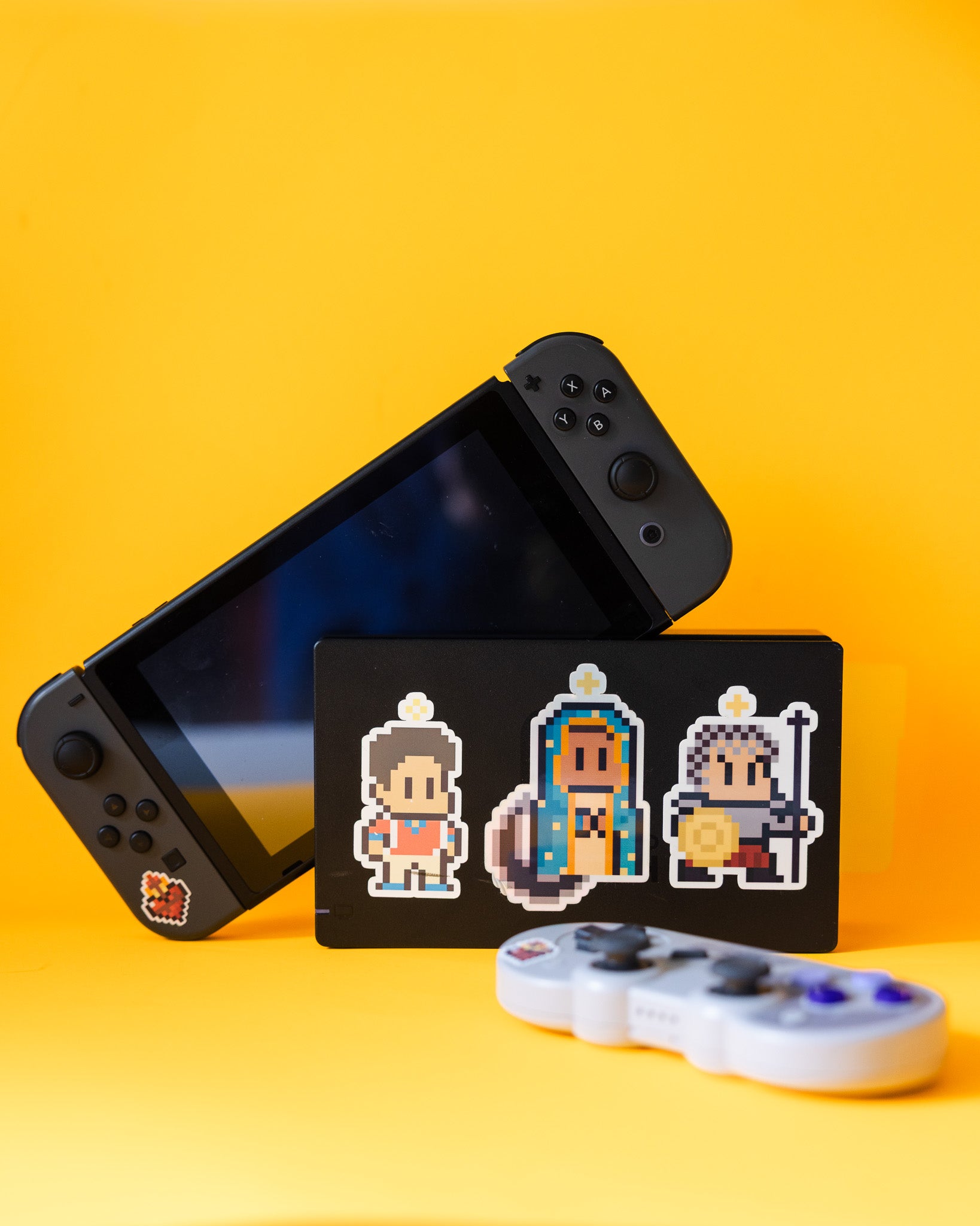Black Nintendo Switch console with a pixel art character card on a yellow background